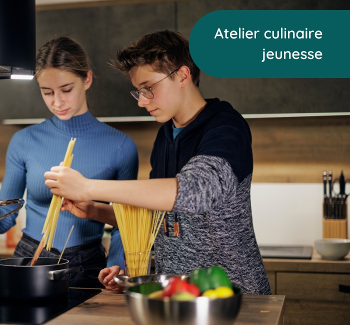 Deux adolescents cuisinant des pâtes ensemble.