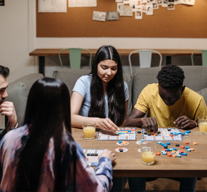 Photo d'adolescents discutant ensemble tout en jouant à un jeu de société.