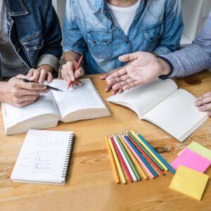 Photo d'un bureau avec des livres ouverts où travaille un petit groupe.